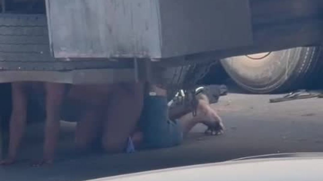 Truck driver under the trailer